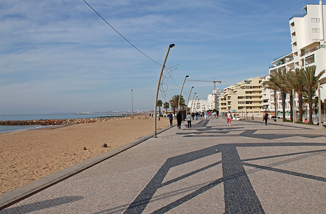 Den vackra palmkantade strandpromenaden, Avenida Infante de Sagres, i Quarteira.