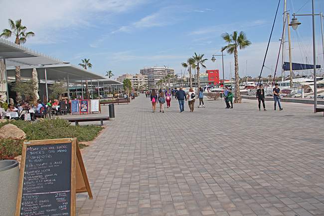 Den breda strandpromenaden mitt emot hamnen kantas av många restauranger.