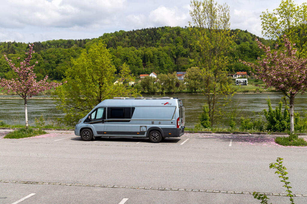 Parkering mellan blommande träd direkt vid flodstranden.