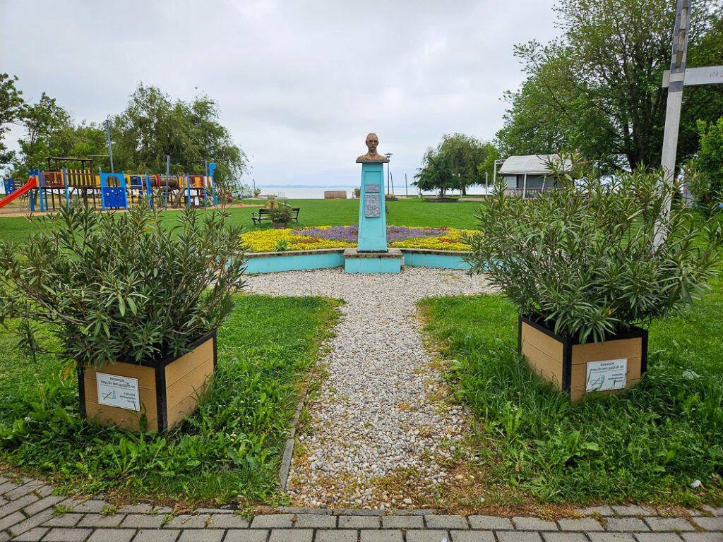Fint ordnad badplats med planteringar och lekpark.
